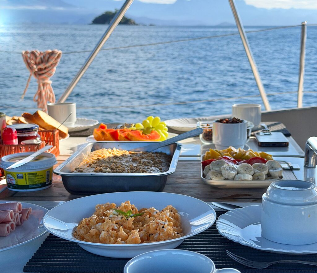 café da manhã a bordo, com frutas, bolos e café.