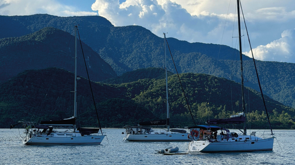 Barcos ancorados e motanhas verdes ao fundo