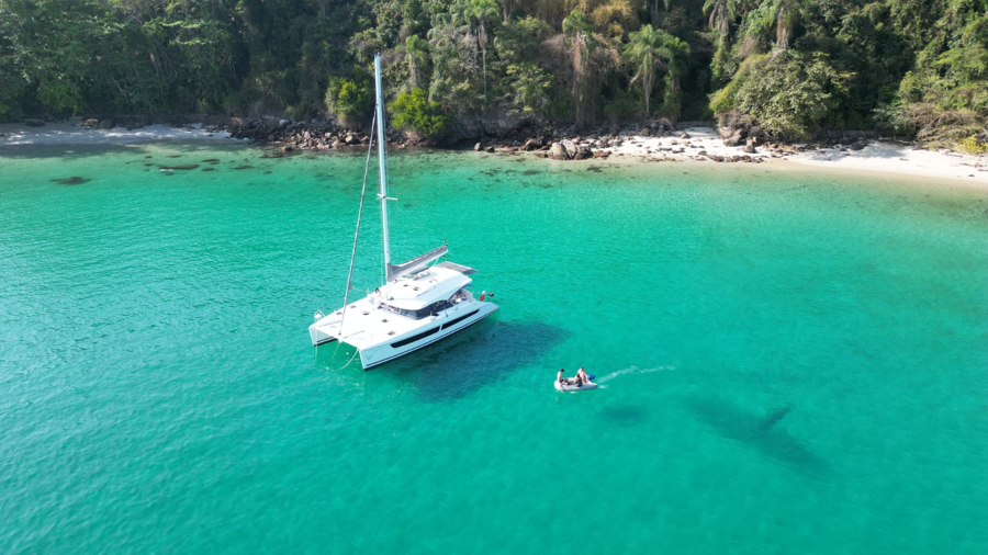 Catamaran ancorado em uma baía de água cristalina em Paraty,RJ, Brasil