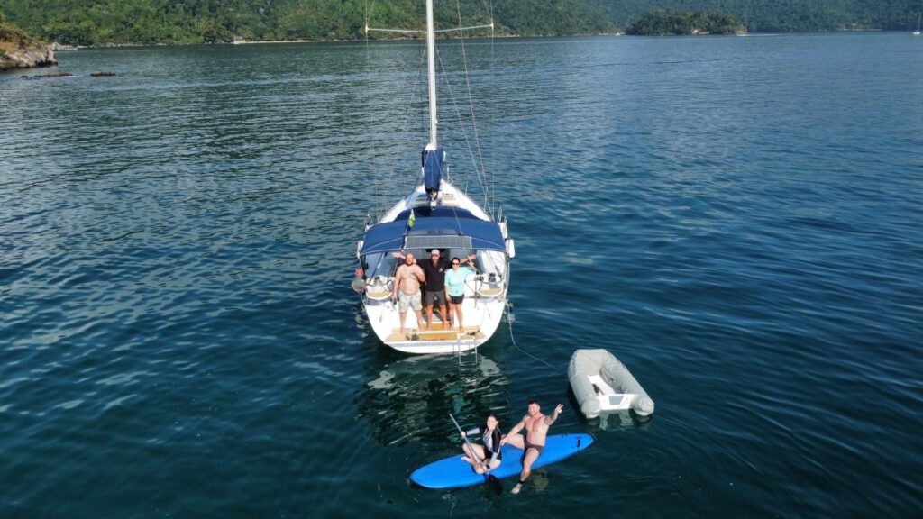 Pessoas felizes em um barco ancorado em uma da baias de Paraty-RJ