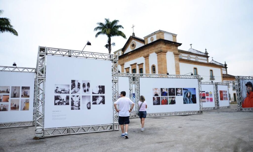 Foto de pessoas olhando painéis de um evento no centro histórico de Paraty, RJ.